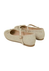 Glitzernde goldene Ballerinas mit runder Zehe, Knöchelriemen und Schleifendetail. Glatte Textur mit flacher Gummisohle und subtiler Ausstrahlung.