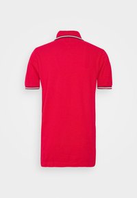 Rotes Polohemd mit kurzen Ärmeln, einem Kragen und gestreiften Akzenten an den Bündchen; aus weichem, strukturiertem Baumwollstoff gefertigt.