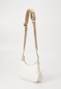 White leather handbag with a curved silhouette, gold hardware, and a detachable beige strap. Features a subtle embossed pattern.