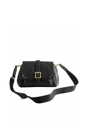Sac bandoulière en cuir noir avec boucle avant, ferrures dorées et sangle en tissu réglable sur fond blanc.