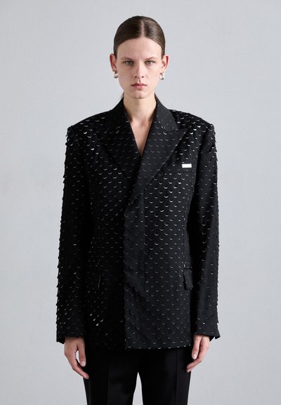 Blazer noir à double boutonnage avec une surface texturée ornée d'accents circulaires, des revers larges et des poches avant. Tissu lisse avec un design structuré.