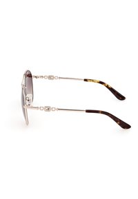 Gafas de sol con un marco de metal plateado, lentes oscuros en degradado y patillas con acentos de carey. Presenta elementos decorativos en las patillas.