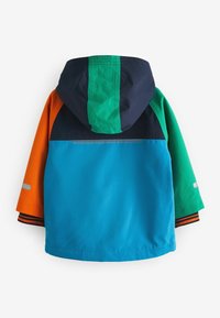 Barnens färgblockerade regnjacka med blå baksida, marinblå och grön huva, orange vänsterärm och grön högerärm, med reflexstripes på ärmarna.