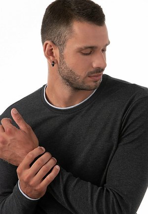 Donkergrijze langarmshirt met een ronde hals. Voorkant heeft een contrasterende lichtgrijze bies bij de kraag. Zachte stoftextuur.