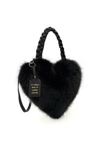 Borsa a forma di cuore nera in pelliccia sintetica con manico intrecciato, dotata di un'etichetta in pelle con testo dorato attaccata.
