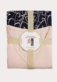 Rosa gerippter Langarm-Top mit marineblauen gemusterten langen Hosen, gesichert mit einem goldenen Band und einem runden Etikett, das mit "Reine Baumwolle" beschriftet ist.
