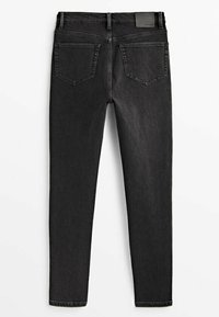Jeans skinny noirs avec deux poches arrière, passants de ceinture, et une étiquette de marque en cuir noire sur la taille, sur fond blanc.