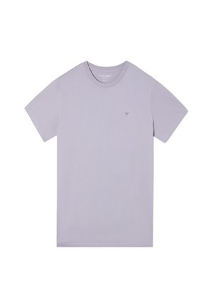 Camiseta corta de manga en color lavanda, hecha de tela suave, con cuello redondo y un logo discreto en el lado izquierdo del pecho. Textura suave.