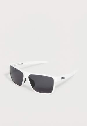 Lunettes de sport rectangulaires blanches avec verres foncés et logo "bliz" sur la branche, présentées sur un fond clair uni.