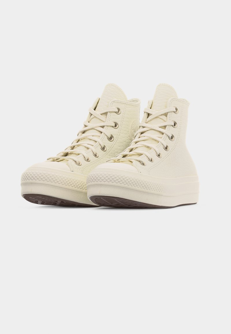 Sneakers alte color crema in pelle testurizzata, con lacci annodati, disposte affiancate su uno sfondo bianco semplice.