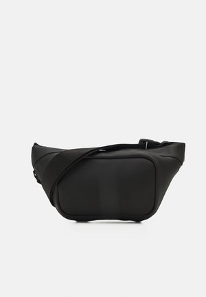 Black waist bag made of smooth, matte material. Features a wide strap, distinctive shape with rounded edges, and subtle branding on the front.