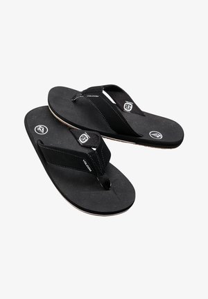 Svarta flip-flops med texturerade gummisulor, tygremmar och logotypdetaljer. Lättviktig och minimalistisk design som passar för avslappnad användning.