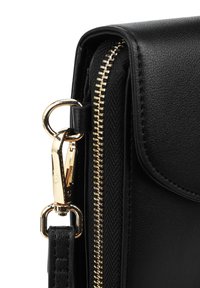 Černá kožená kabelka s zlatým zipem, kovovými detaily a odnímatelným popruhem. Povrch je hladký s švy.