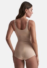 Bodies beige modellanti con bretelle regolabili, texture liscia e design aderente. Presenta una schiena bassa e bottoni sul fondo.