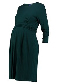 Mamma klänning i mörkgrön tyg, med långa ärmar, en samlad midja och en flödande kjol som rymmer en växande mage.