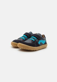 Sneaker neri e blu con suola in gomma, dotati di cinturini in Velcro e dettagli turchesi su una tomaia in suede morbido e mesh.