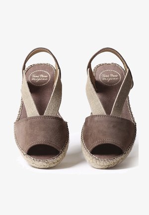 Brązowe zamszowe espadryle z odkrytymi palcami, z beżowym plecionym paskiem w kształcie krzyża i juteową podeszwą. Posiadają haftowaną krawędź oraz wyściółkę z poduszką.