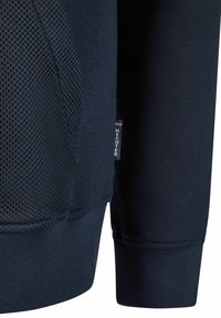 Marine-coloured sweatshirt met een gestructureerd meshpaneel, geribbelde manchetten en een klein merklabel in contrasterende kleuren nabij de zoom.