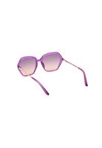 Occhiali da sole esagonali viola con lenti sfumate, dettagli in metallo dorato e aste trasparenti viola.