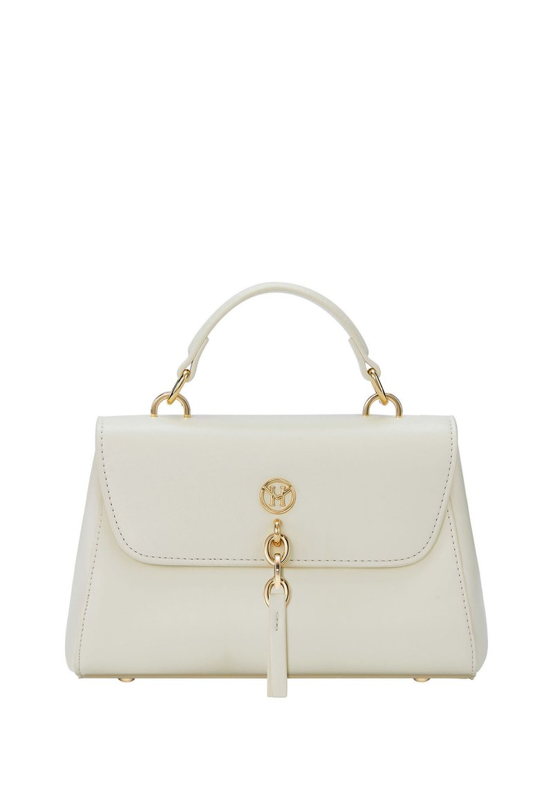 Bolso de mano de cuero crema con asa superior, logo circular dorado y detalle de anillo dorado en el cierre de la solapa frontal.