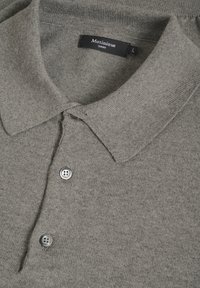 Polo shirt grigio lavorato a maglia con colletto, caratterizzato da tre bottoni, un'etichetta con la scritta "Matinique" e taglia "L". Texture morbida e design semplice.
