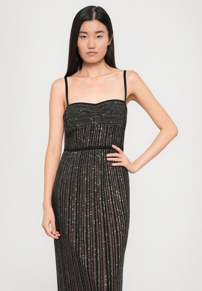 Black strapless dress with vertical sequin stripes. Fitted bodice and flowing skirt. Smooth texture, minimalistic design, and subtle shimmer accents.