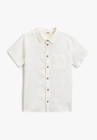 Camisa de manga corta y cuello en tela beige claro. Presenta un bolsillo frontal y botones marrones a lo largo de la placket. Textura suave.