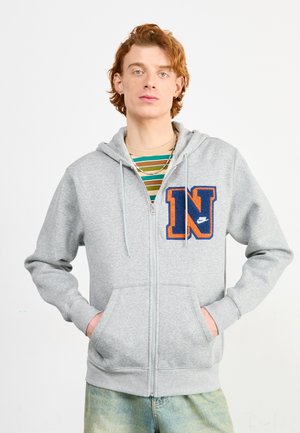Light gray zip-up hoodie made of fleece material, featuring a large navy and orange "N" logo on the left chest and front pockets.