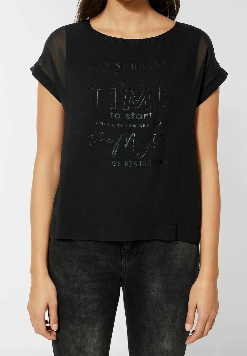 Svart kortärmad topp med rund halsringning, prydd med text av texturiserad metallisk finish på framsidan. Tillverkad av lätt tyg med en avslappnad passform.