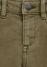 Olijfgroene katoenen broek in een mix met een textuurafwerking. Heeft een metalen knop met de tekst "Blue Ridge" en gestikte riemlussen op een vlakke voorkant.