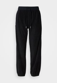 Czarne dresy z polaru z elastycznym pasem, regulowanym sznurkiem oraz zwężanymi nogawkami. Teksturowany materiał z bocznymi kieszeniami.