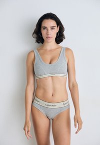 Szürke pamut sportmelltartó és hozzáillő bikini bézs logós pánttal, egyszerű dizájnnal és sima textúrával.