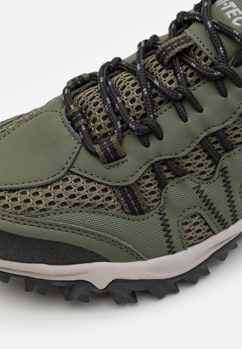 Le scarpe da atletica verdi presentano una tomaia in rete, accenti neri e grigi, lati testurizzati e una suola in gomma robusta con scanalature profonde per una migliore aderenza.