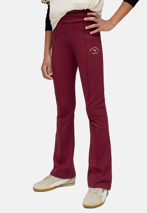 Bordeaux sportbroek met een aangesloten taille en uitlopende onderkant, voorzien van een wit logo-detail op de dij en een gladde, elastische stof.
