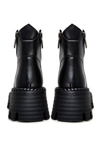 Bottines en cuir noir avec semelles compensées épaisses à rainures, vues de dos, avec fermetures éclair latérales et coutures décoratives.