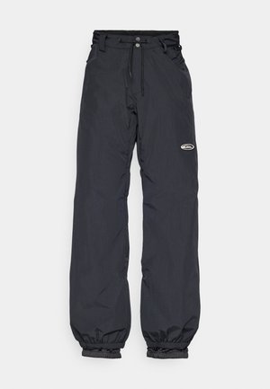 Pantalons imperméables noirs avec une taille ajustable, des poignets élastiques et une petite étiquette logo sur la cuisse ; tissu léger.