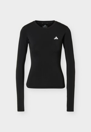 Fekete hosszú ujjú, testhez simuló sportfelső kerek nyakkal és kis fehér Adidas logóval a bal mellkason.