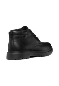 Botas de tobillo de cuero negro con puntera redonda, diseño con cordones y suela de goma texturizada; presenta un acabado liso y costuras mínimas.