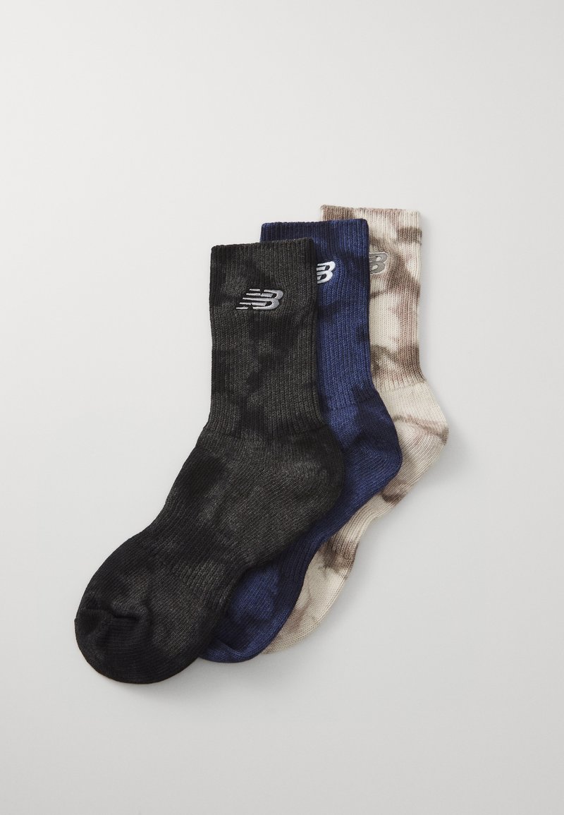 Trzy pary skarpetek: czarne z fakturowanym wzorem, ciemnoniebieskie oraz jasnobeżowe z efektem tie-dye. Każda z nich ma logo New Balance.