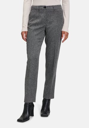 Pantaloni in gessato grigio con design a gamba dritta, caratterizzati da chiusura a bottone e tasche laterali, abbinati a stivali neri con tacco.