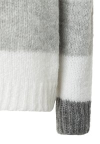 Mouw van een wollen trui met horizontale strepen in lichtgrijs, donkergrijs en wit. Geribbelde boord in donkergrijze textuur.