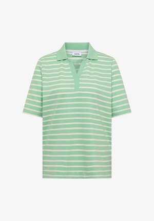 Personne portant une chemise à manches courtes rayée verte et blanche rentrée dans un jean en denim bleu clair avec une poche avant visible et un bouton.