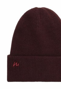 Burgundin värinen neulottu pipo, jossa on taitettu malli. Siinä on pieni brodeerattu logo tummemman punaisena taitetulla reunalla.