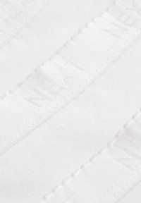 Witte stof met een subtiele textuur, met een band waarop het woord "NEXT" in een herhalend patroon is geembosteerd langs de lengte.