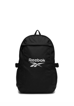Sort Reebok rygsæk med forreste lynlåslomme, sidelommer i net og justerbare stropper vist på hvid baggrund.