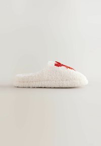 Weiße, flauschige Hausschuhe mit einer weichen Textur, die auf der Seite ein rotes Blumenstickmuster zeigt. Zum Hineinschlüpfen geeignet, mit runder Zehenpartie.