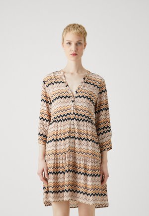 Korte ermer, knapp-ned kjole i oransje, svart og hvit zigzag mønster; lett stoff; volang kant; V-hals design.