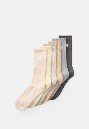 Ensemble de six paires de chaussettes côtelées dans des teintes variées : beige, crème, gris clair, marron clair, gris foncé et charbon, avec des accents de logo blanc.