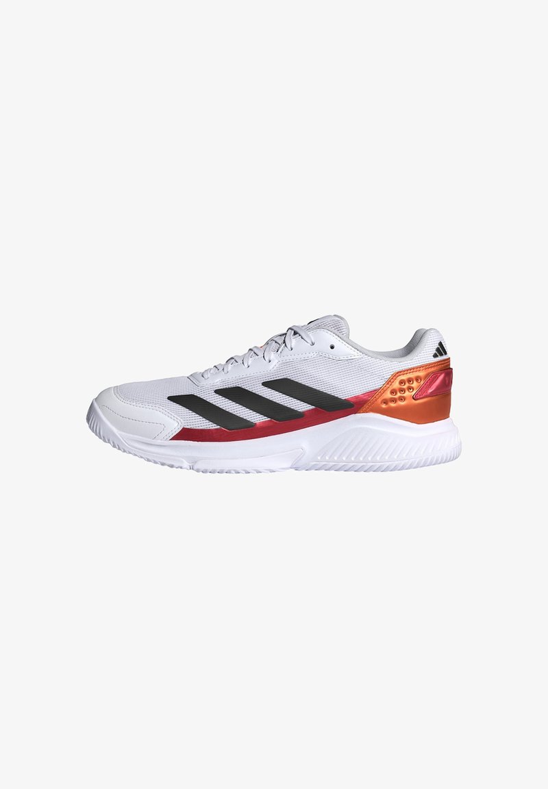 Chaussure de sport blanche avec des rayures noires, des accents rouges et orange, une semelle blanche et une fermeture à lacets, vue de côté sur fond blanc.