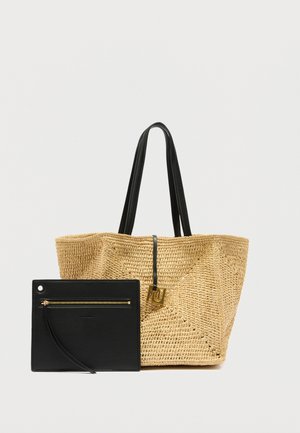 Kudottu olkitote-kassi, jossa on kaksi mustaa kahvaa ja irrotettava musta nahkainen pussi, jossa on vetoketju ja ranneke.